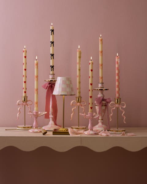 Taper candles and candleholders decorated with hearts, bows and plaid patterns.