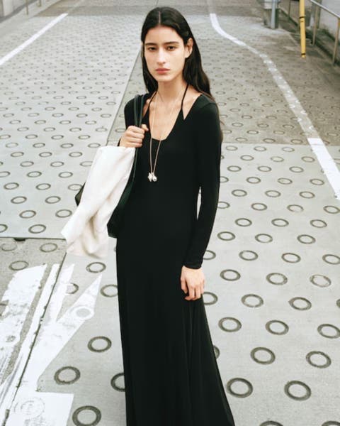 Woman wearing black MANGO dress.