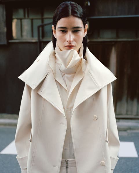 Woman wearing white MANGO trench coat.