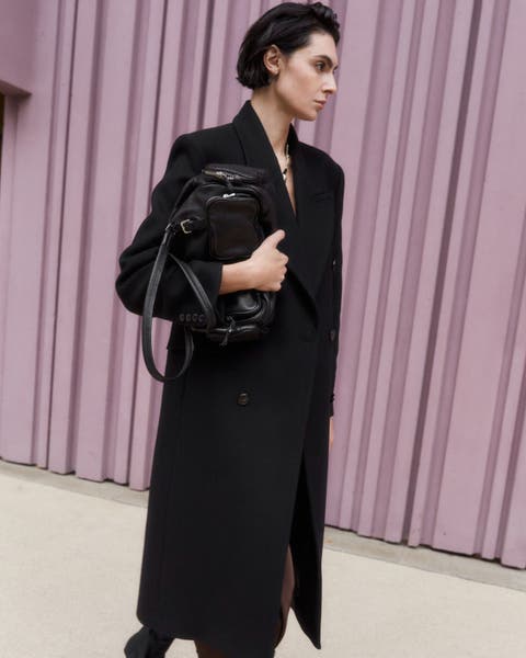 Model wearing black Mango peacoat.