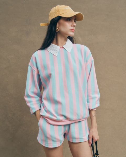 A woman wearing a matching striped sweatshirt and shorts.