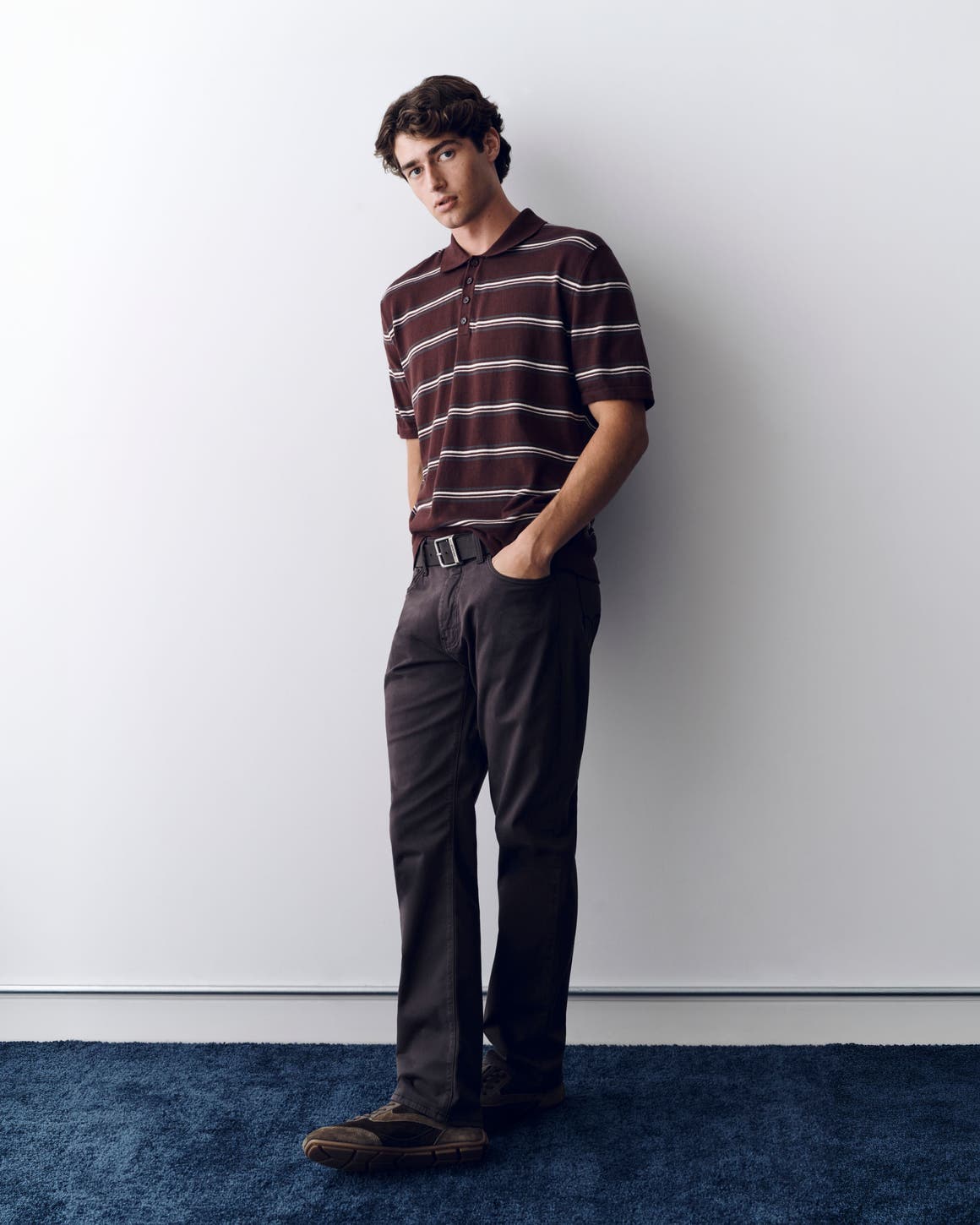 A man wearing Mavi Jeans and a striped polo. 