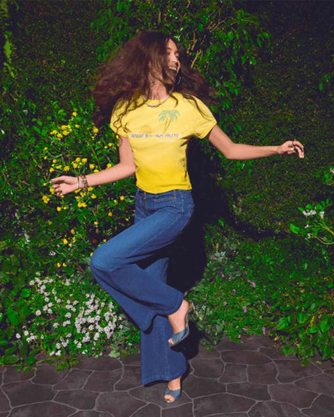 Woman wearing petite MOTHER denim and a yellow graphic tee.