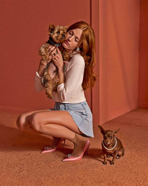 Woman holding a dog wearing a MOTHER denim skirt and white top.