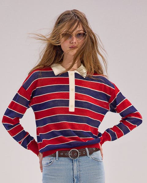 A woman wearing a long sleeve, striped polo shirt.