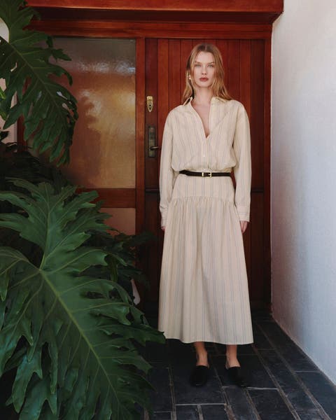A woman wearing a striped shirtdress with a belt.