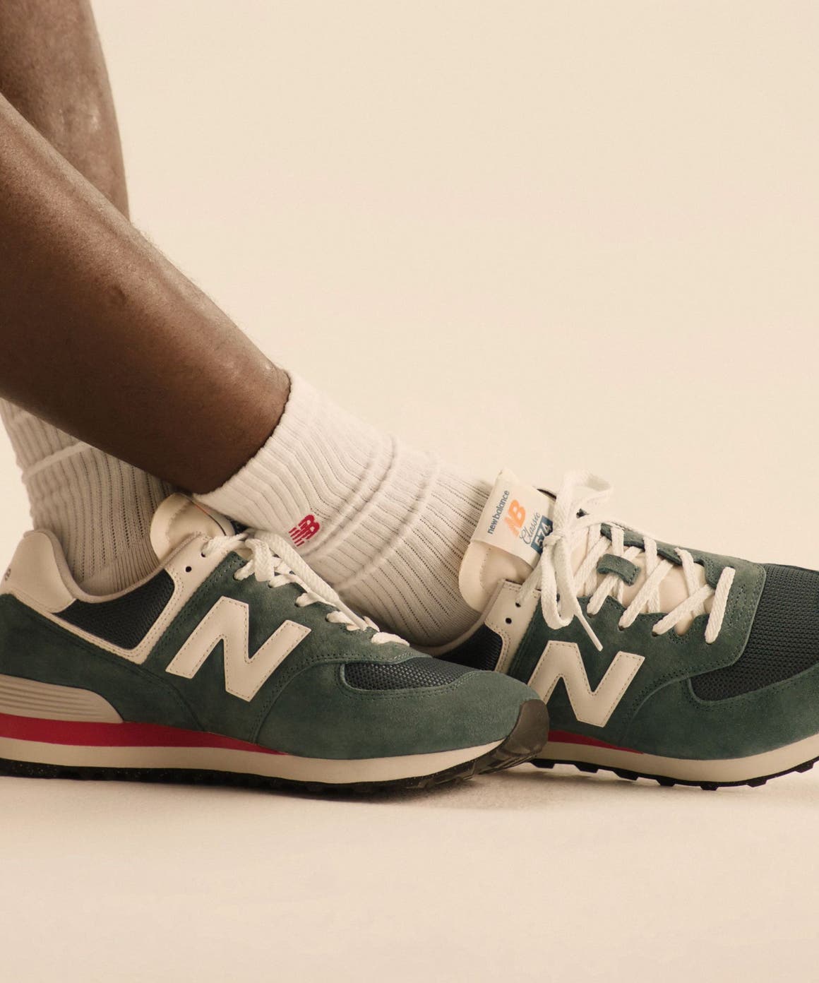 Model wearing crew socks and athletic sneakers from New Balance.