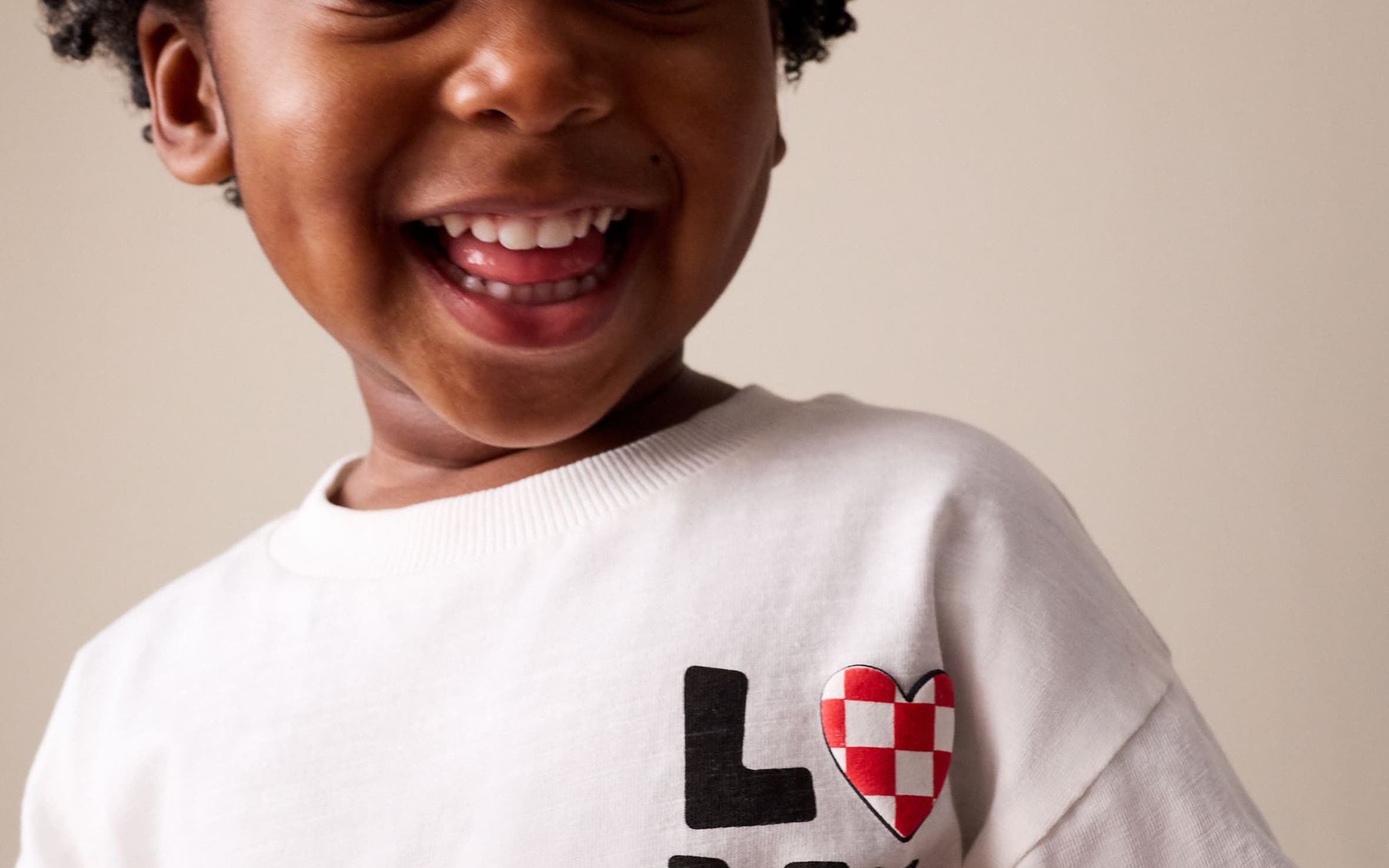 Little boy wearing a white t-shirt that says LOVE.