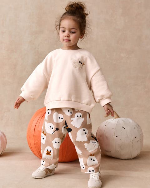 A little girl wearing a ghost matching sweats set from NEXT.