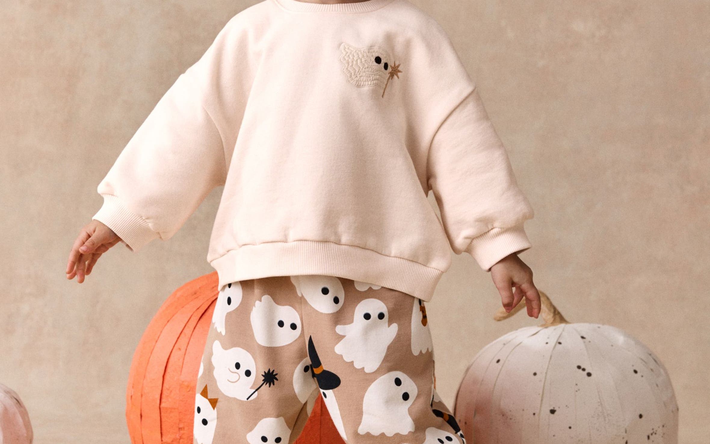 A little girl wearing a ghost sweatsuit from NEXT.