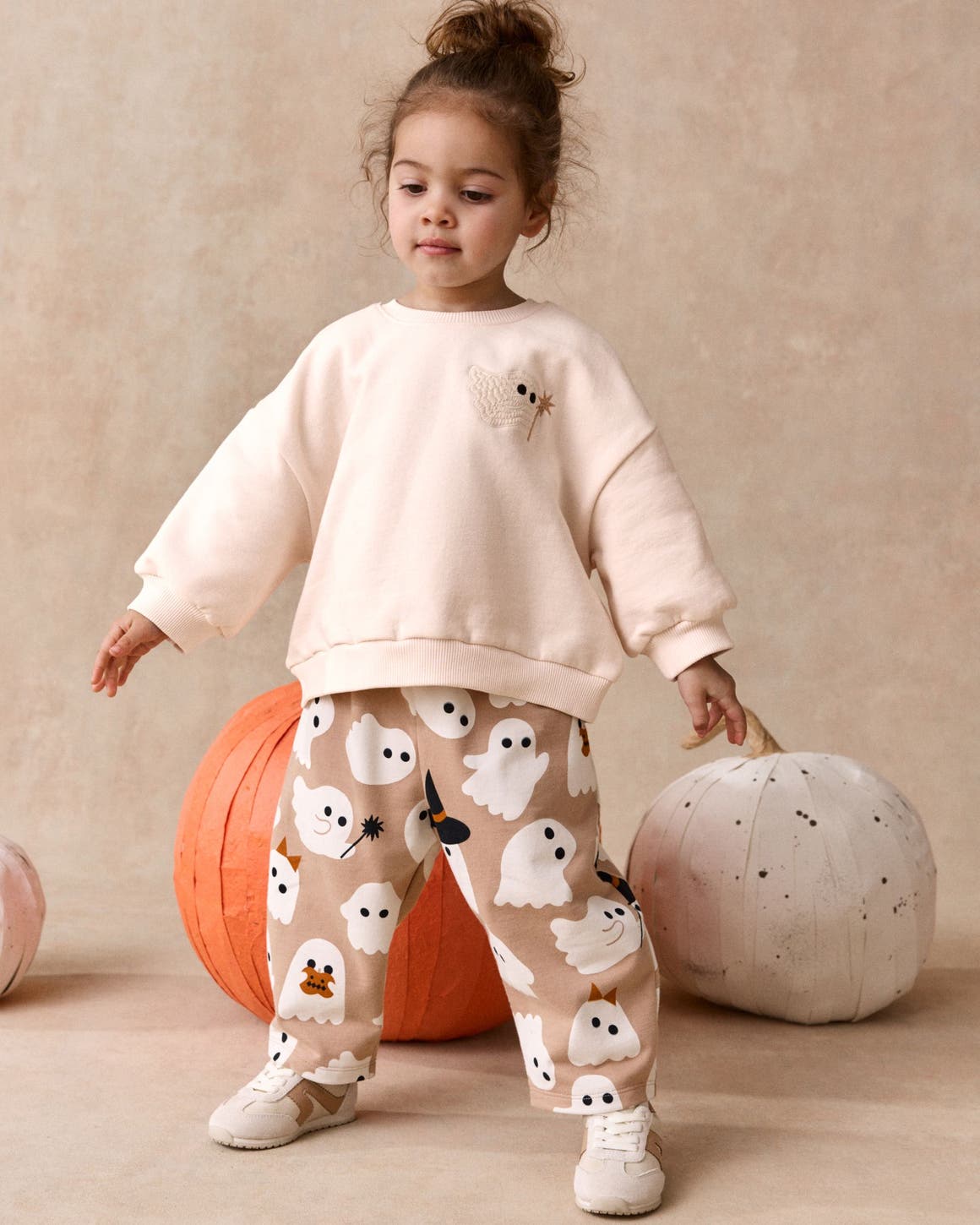 A little girl wearing a ghost sweatsuit from NEXT.