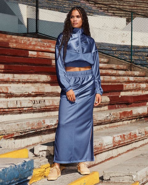 Woman wearing blue Nike jacket and skirt.