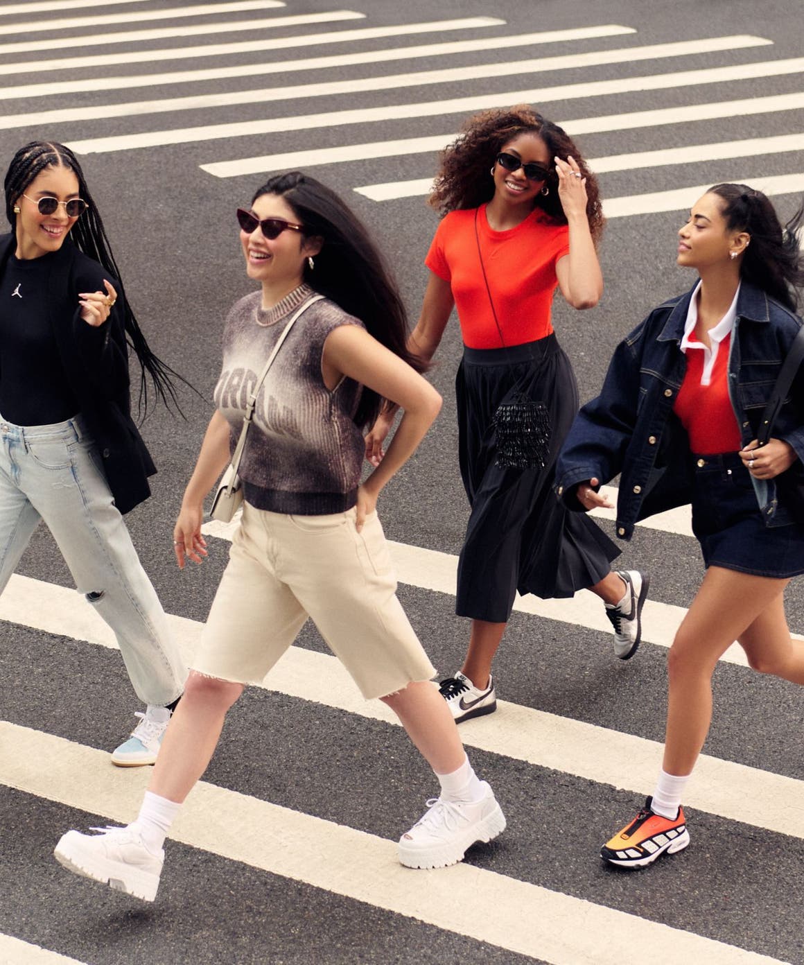 Four women crossing a street and wearing Nike clothes, shoes and accessories.