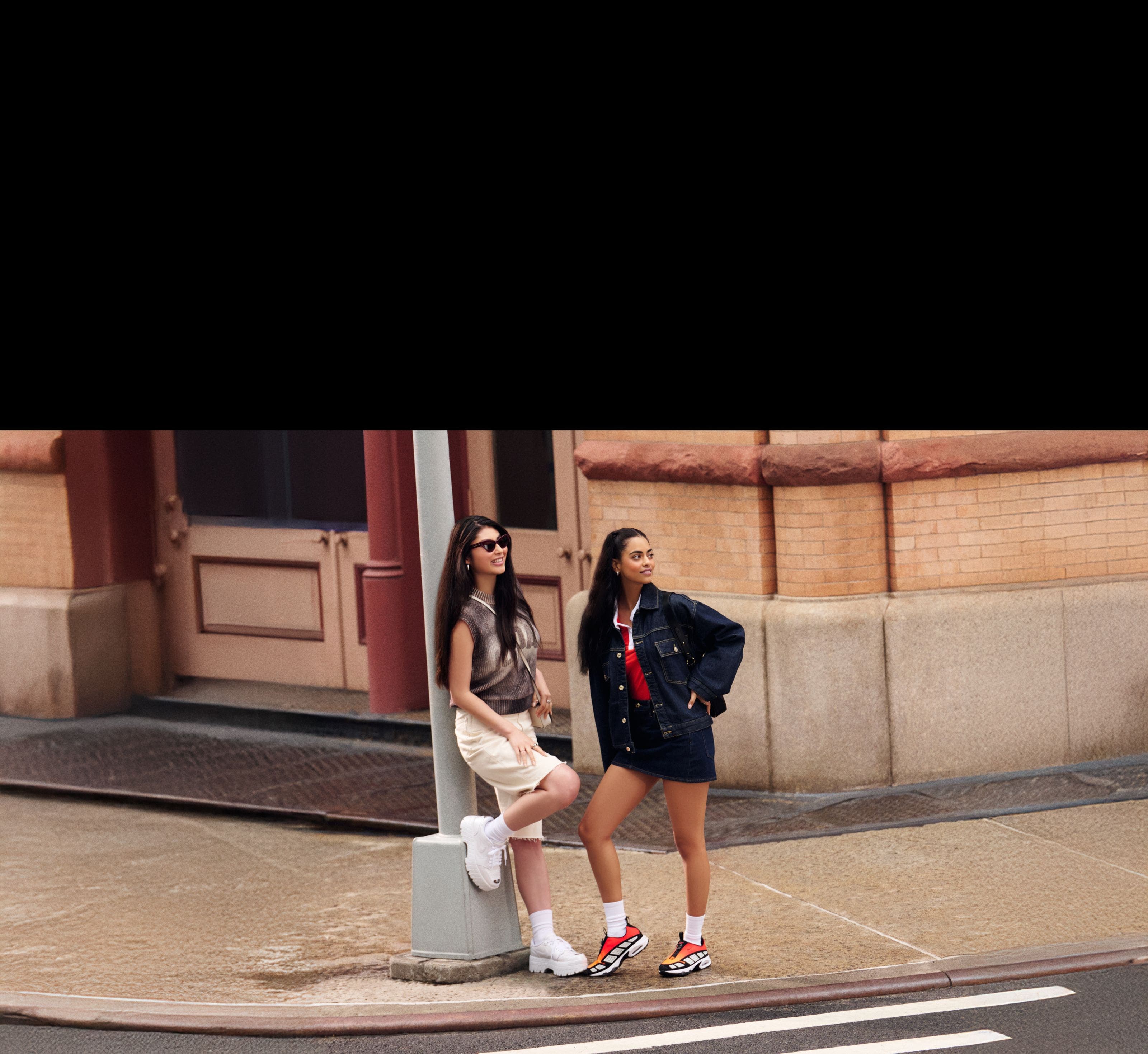 Two women wearing Nike and Jordan clothing, shoes and accessories.