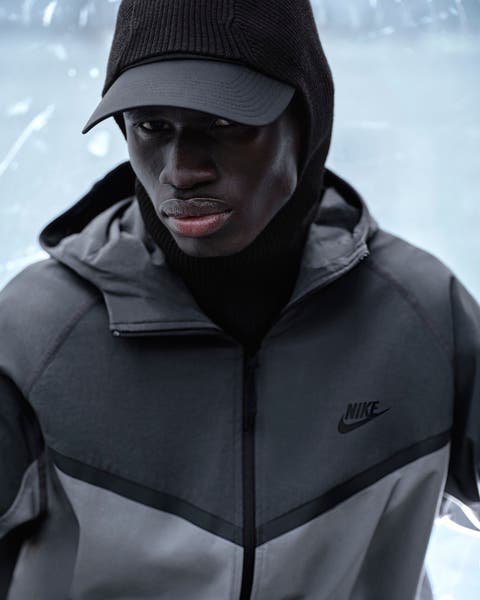 Man wearing a black Nike hat and Nike zip up jacket