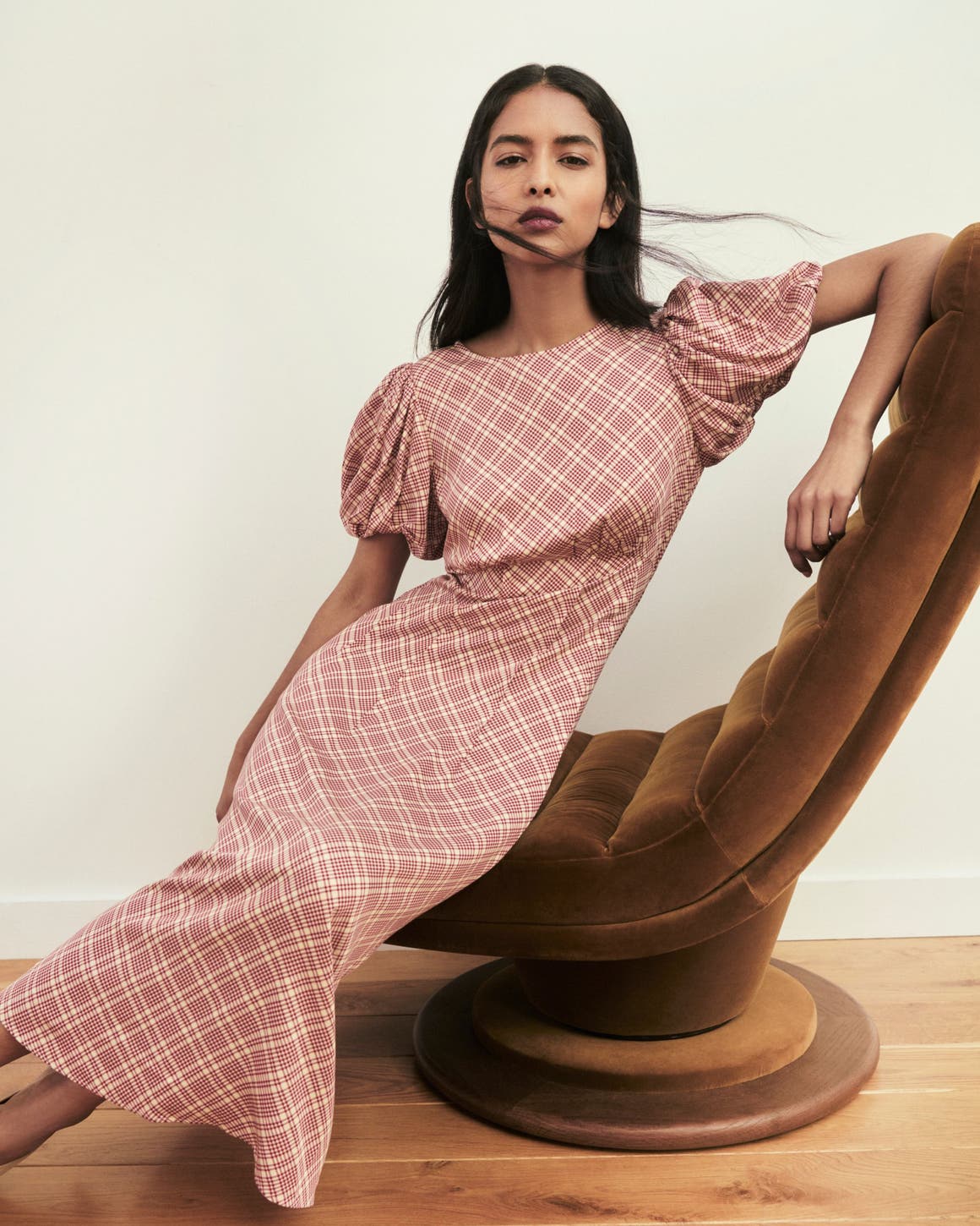 A woman wearing a pink plaid dress.
