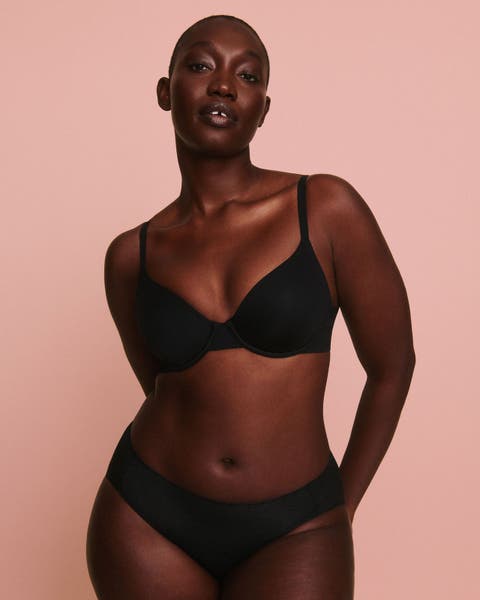 Woman wearing a black SPANX bra.