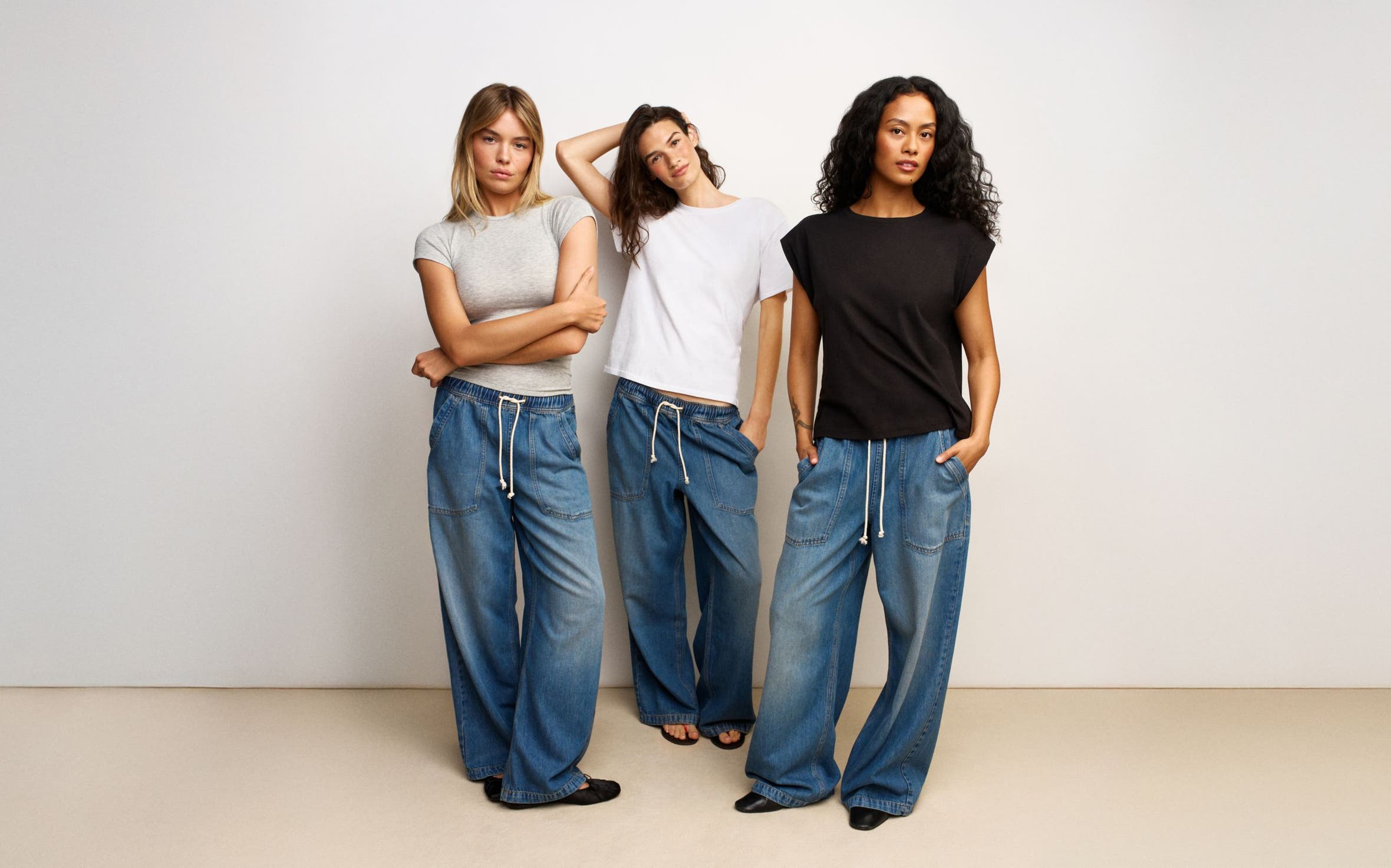 Three women wearing tees and pull-on jeans.