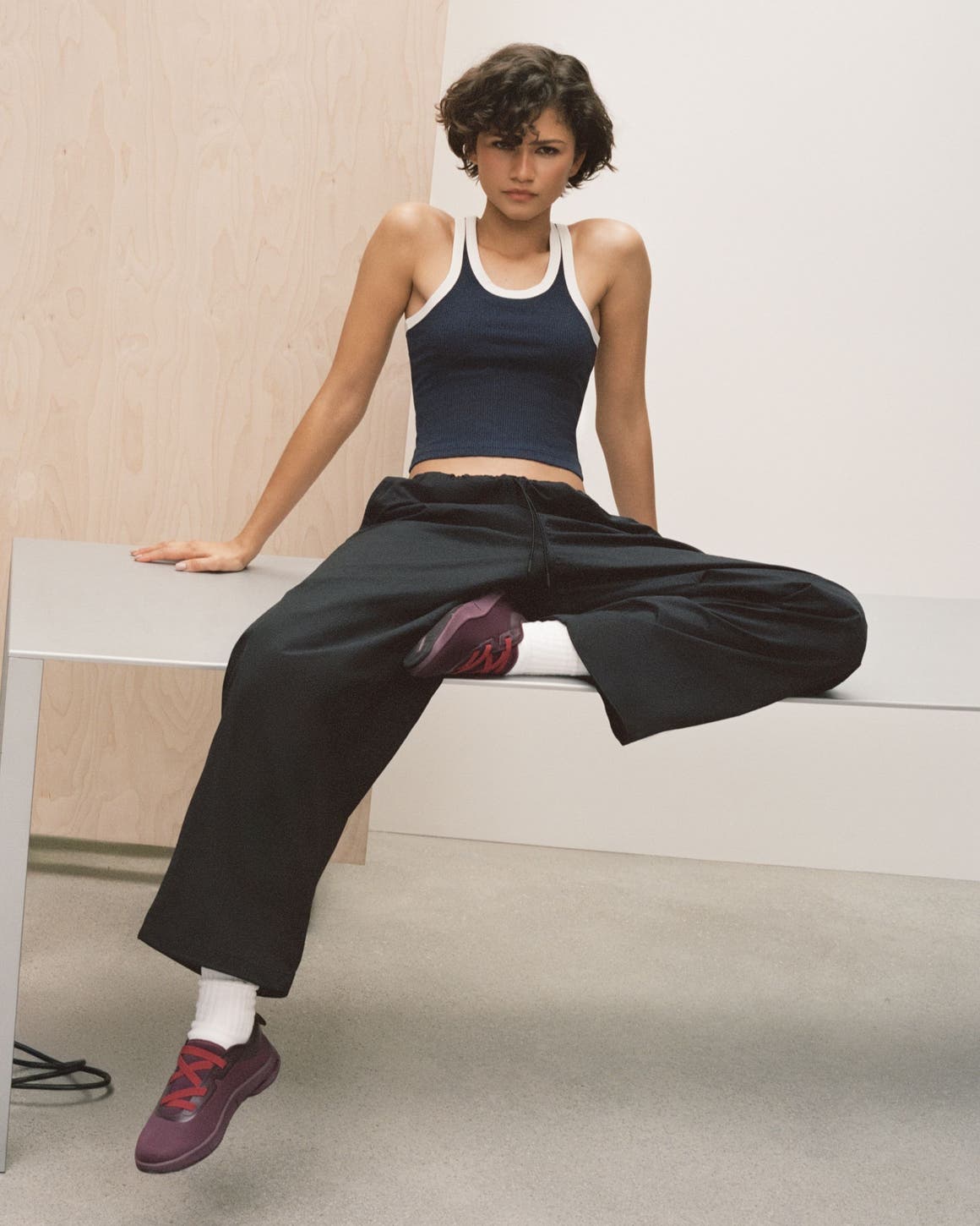 Zendaya wearing On Running shoes, track pants, and tank top.