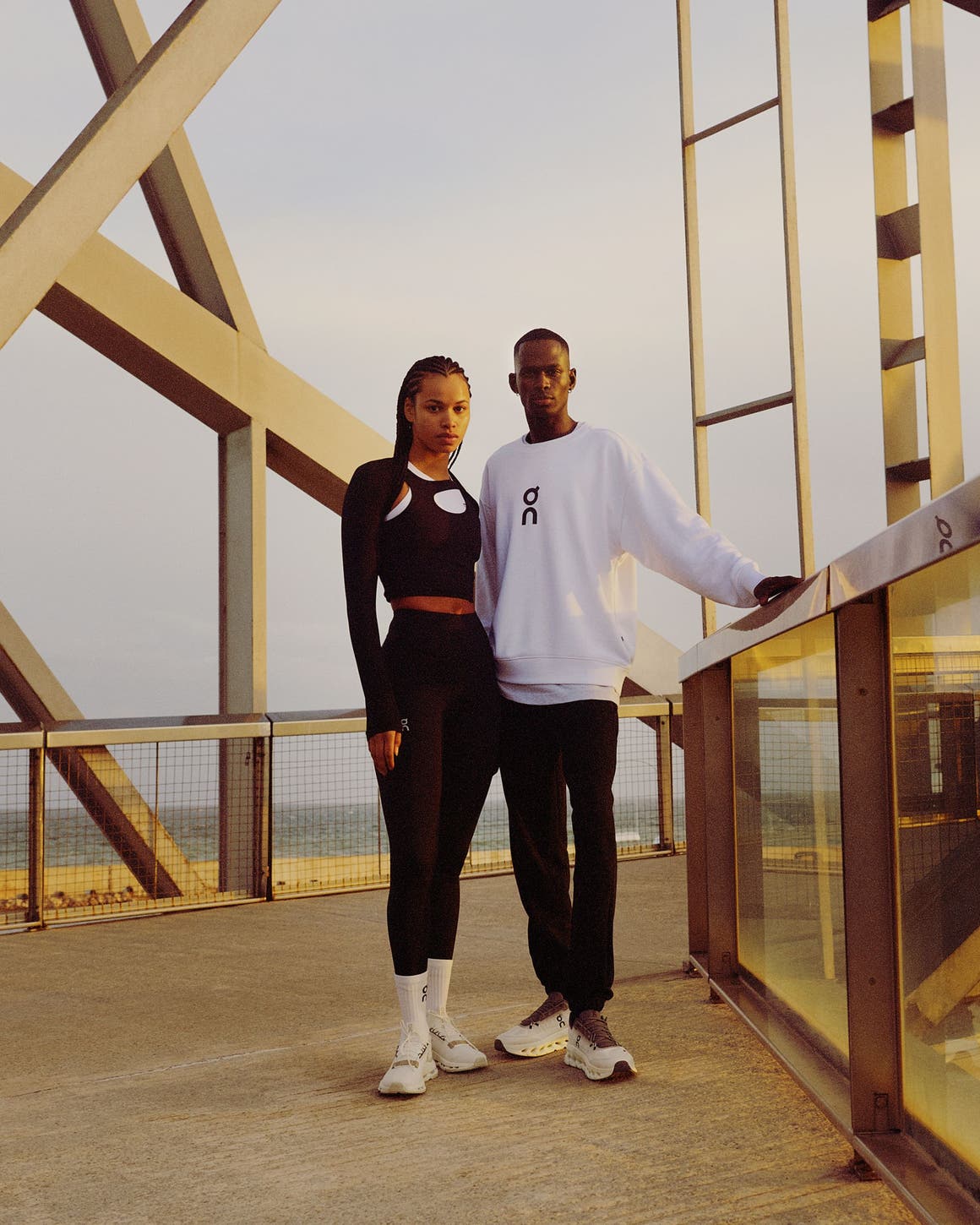 Woman and man wearing athletic apparel and sneakers from On.