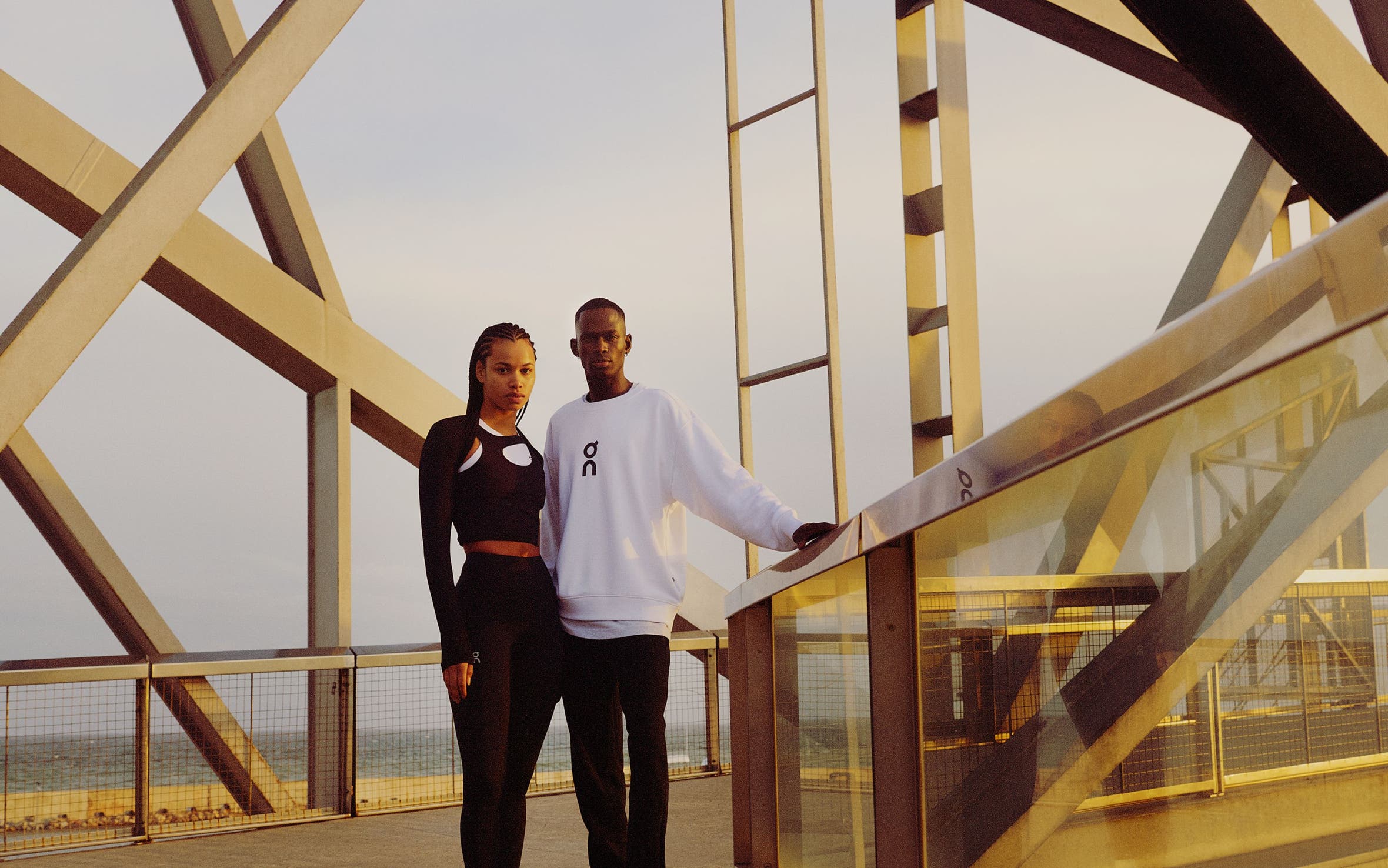 Woman and man wearing athletic apparel and sneakers from On.