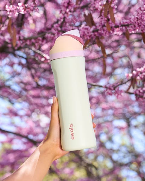 A hand holding an Owala water bottle.