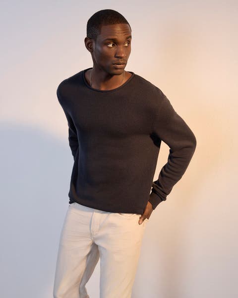 Man wearing black Paige long sleeve and light colored pants.