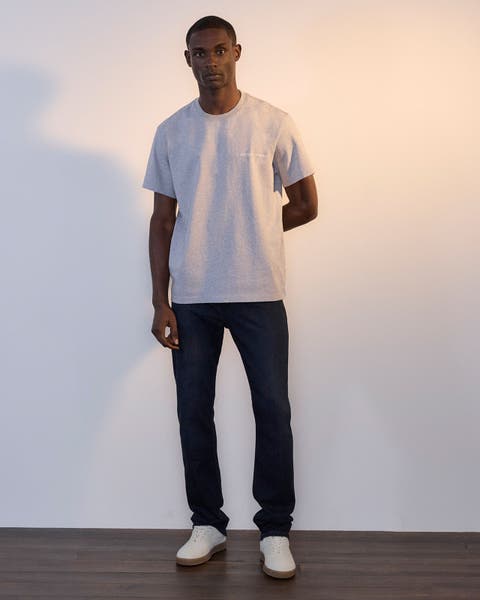 Man wearing grey T-shirt and Paige denim pant.