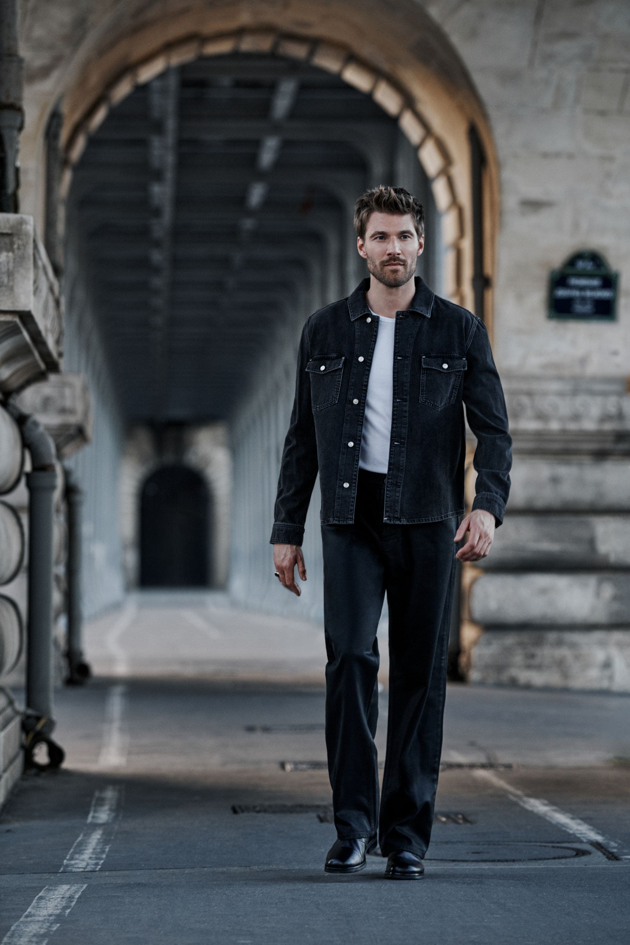 A man wearing PAIGE denim jacket and jeans.