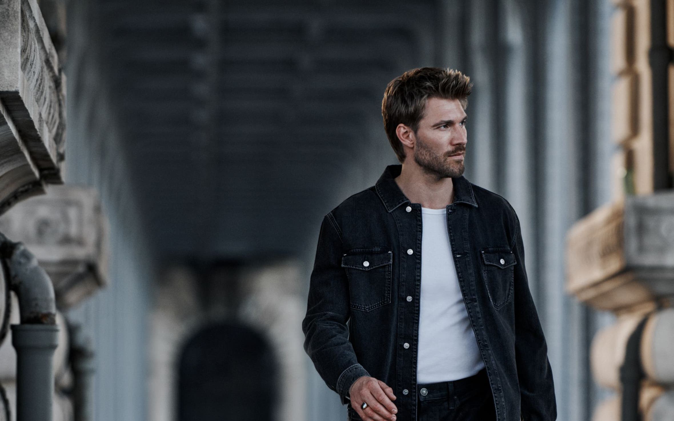 A man wearing PAIGE denim jacket and jeans.