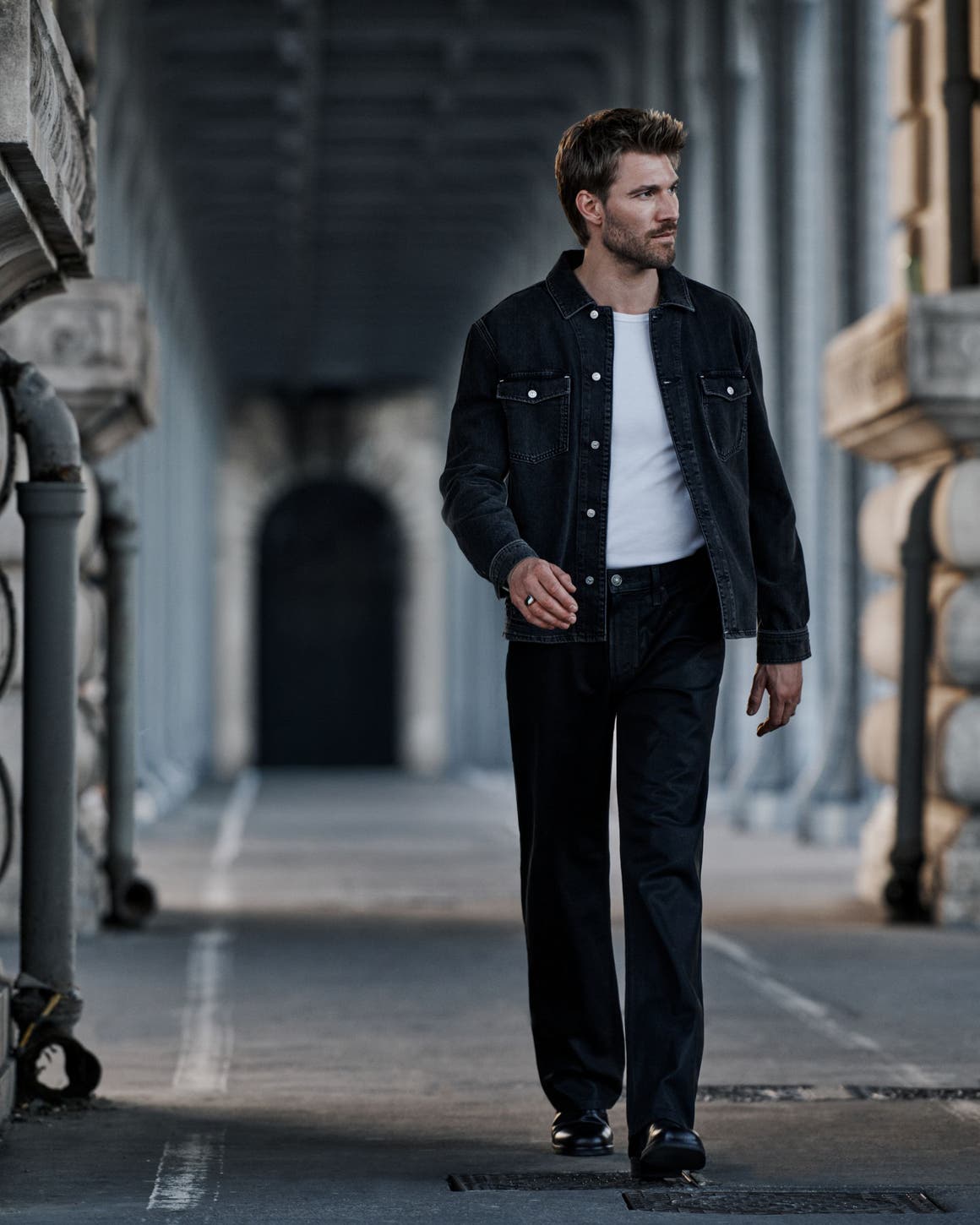 A man wearing PAIGE denim pants and jacket.