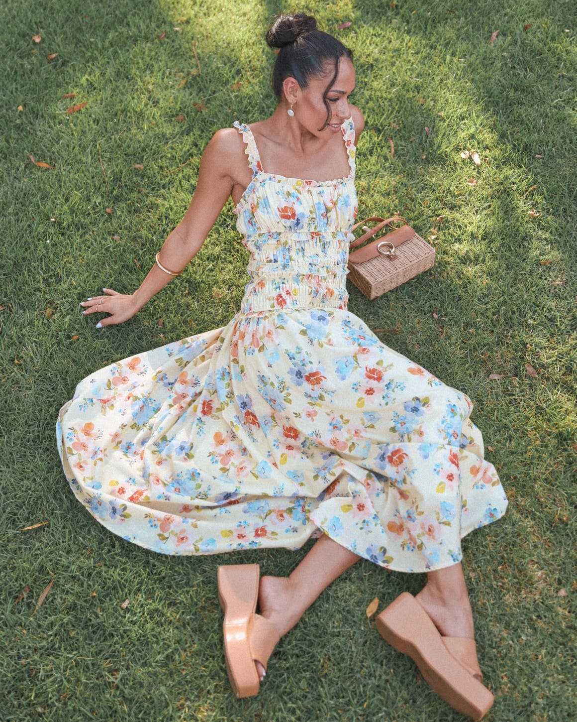A woman wearing a smocked floral-print dress.
