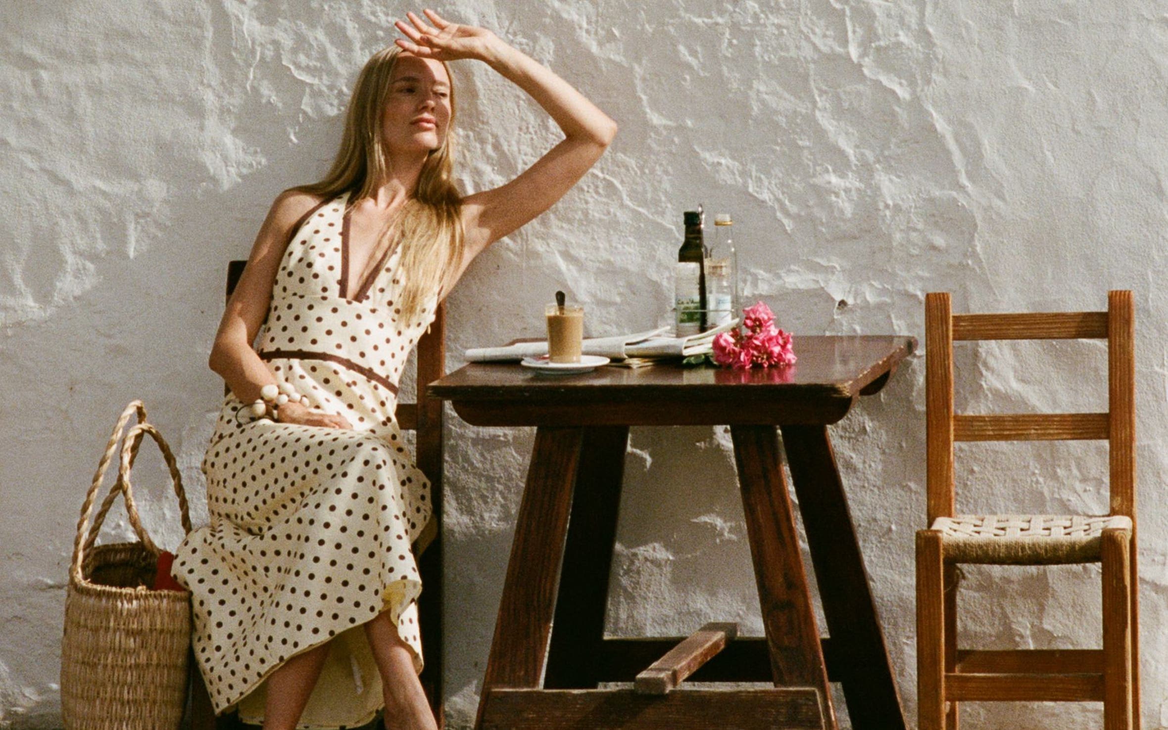 A woman wearing a polka-dotted V-neck dress.