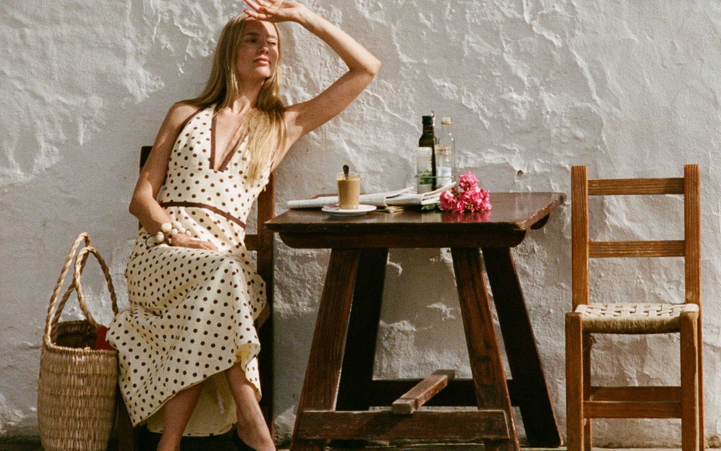 A woman wearing a polka-dotted V-neck dress.