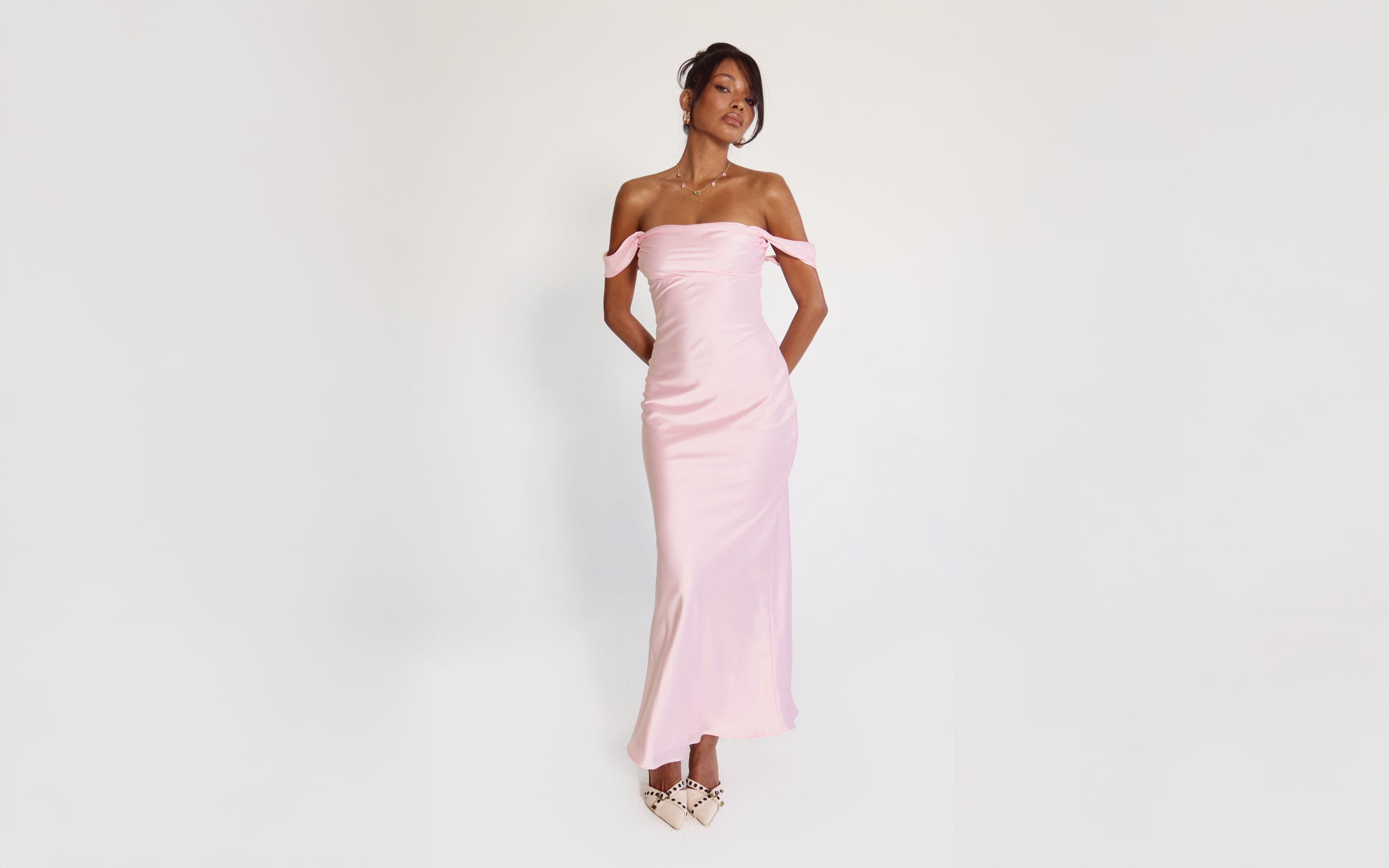 A woman wearing a pink off-the-shoulder gown.
