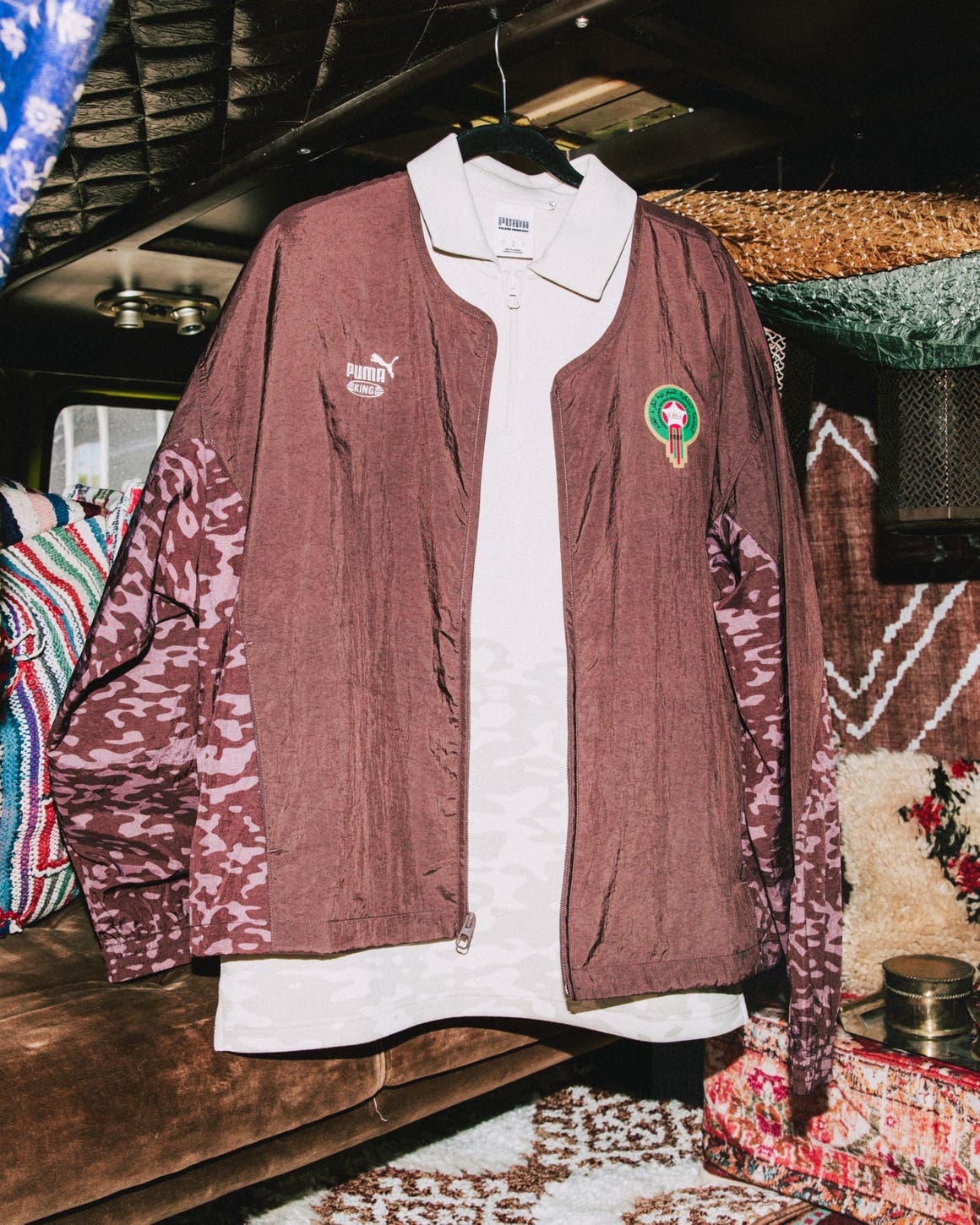 A brown Puma track jacket over a white polo.