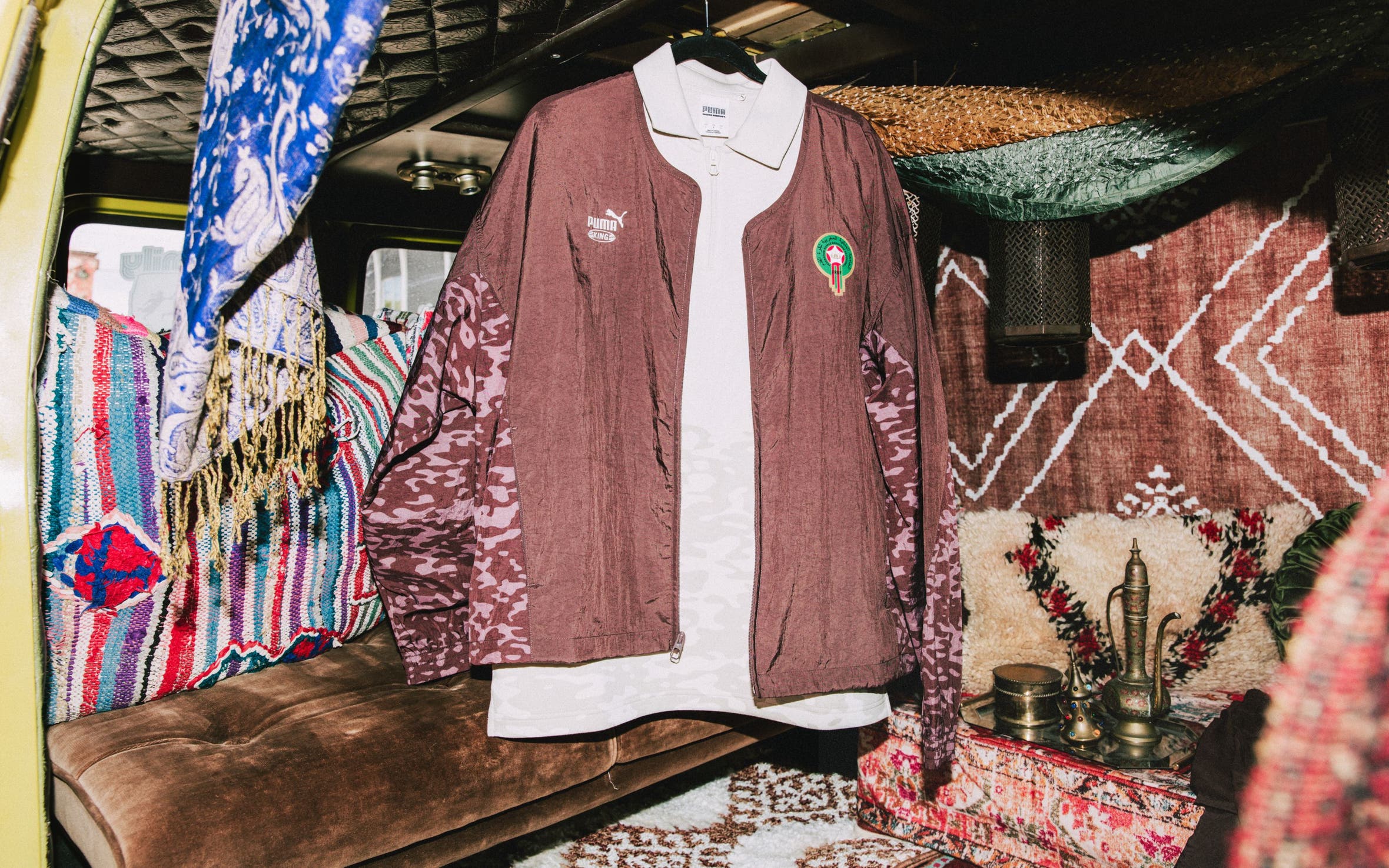 A brown Puma track jacket over a white polo.