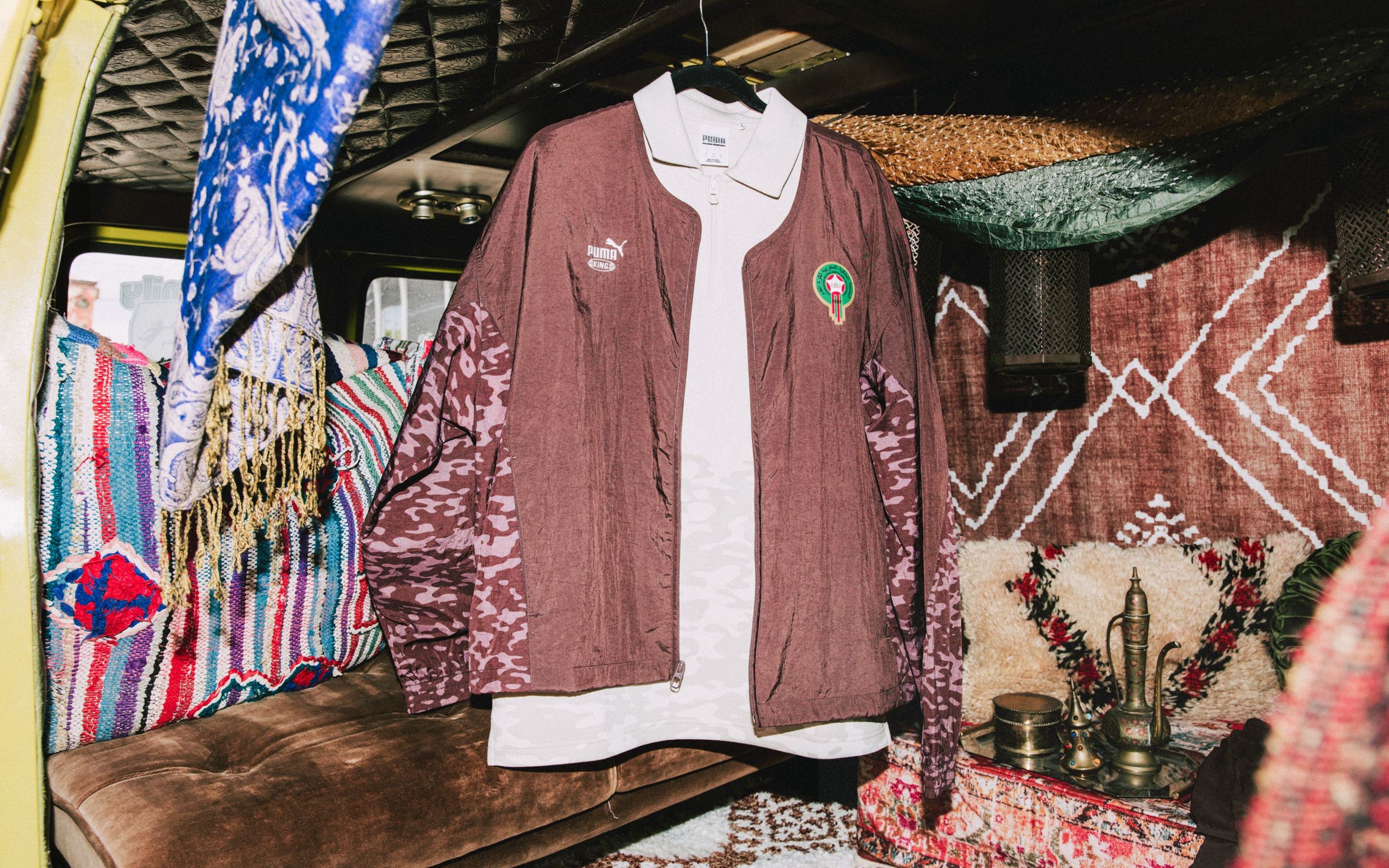A brown Puma track jacket over a white polo.