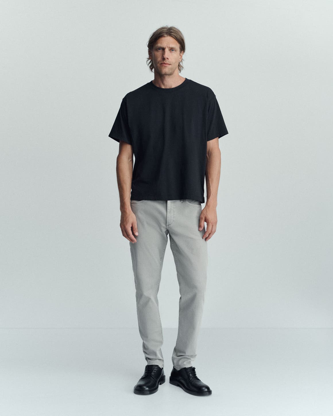 A man wearing rag & bone tee and jeans.