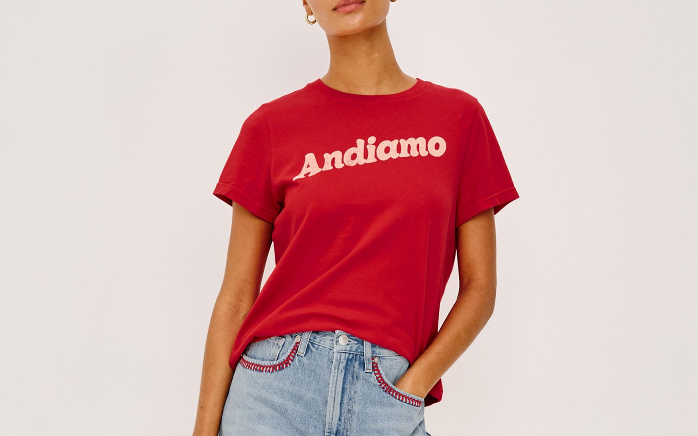 A woman wearing a graphic t-shirt and embellished denim shorts.