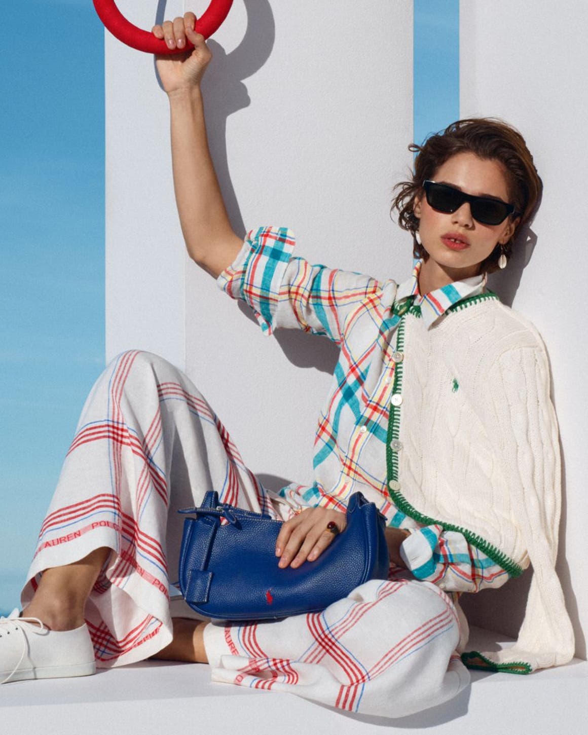 Woman wearing Ralph Lauren cardigan over plaid top and pants.