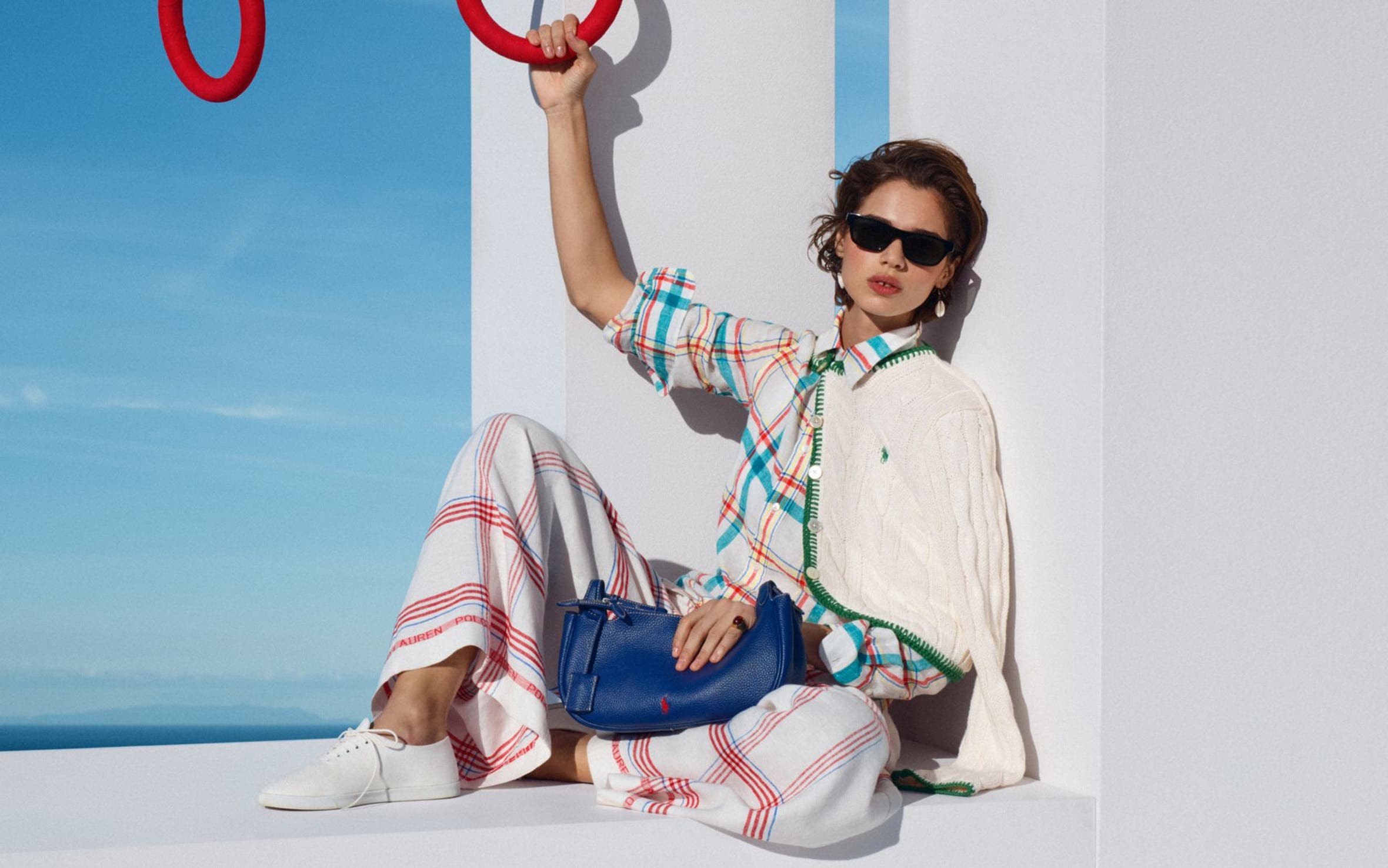 Woman wearing Ralph Lauren cardigan over plaid top and pants.