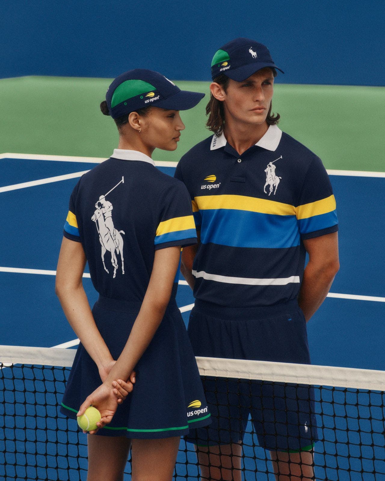 A man and woman wearing matching tennis outfits from the US Open x Polo Ralph Lauren collaboration.