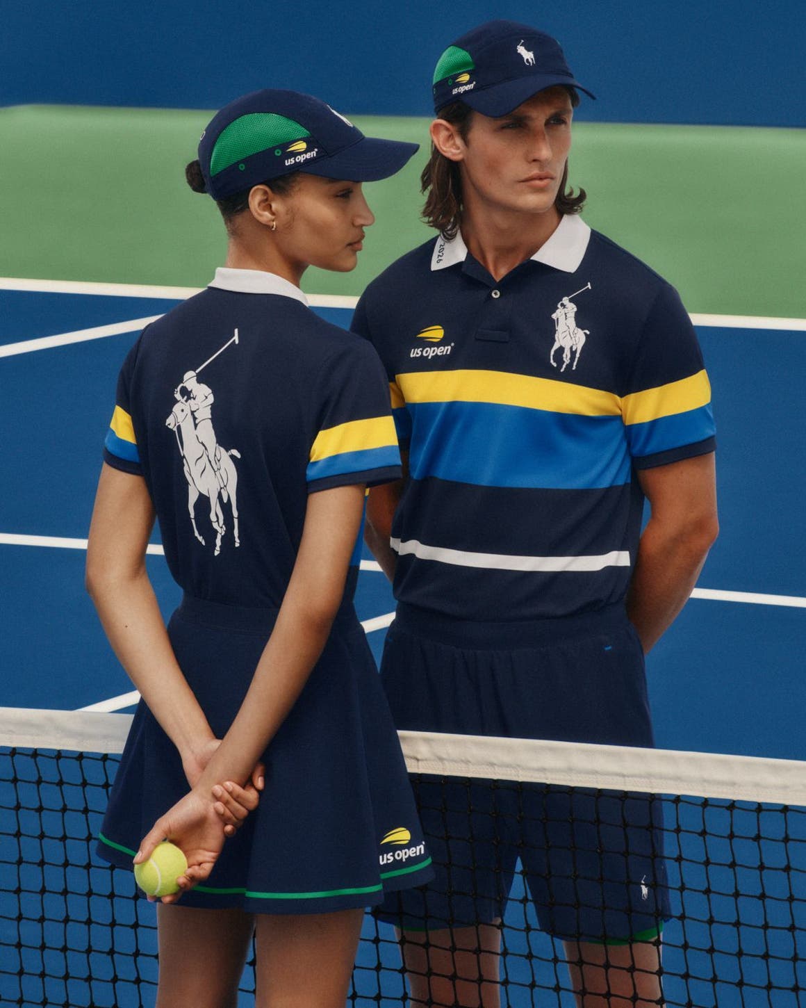 A man and woman wearing matching tennis outfits from the US Open x Polo Ralph Lauren collaboration.