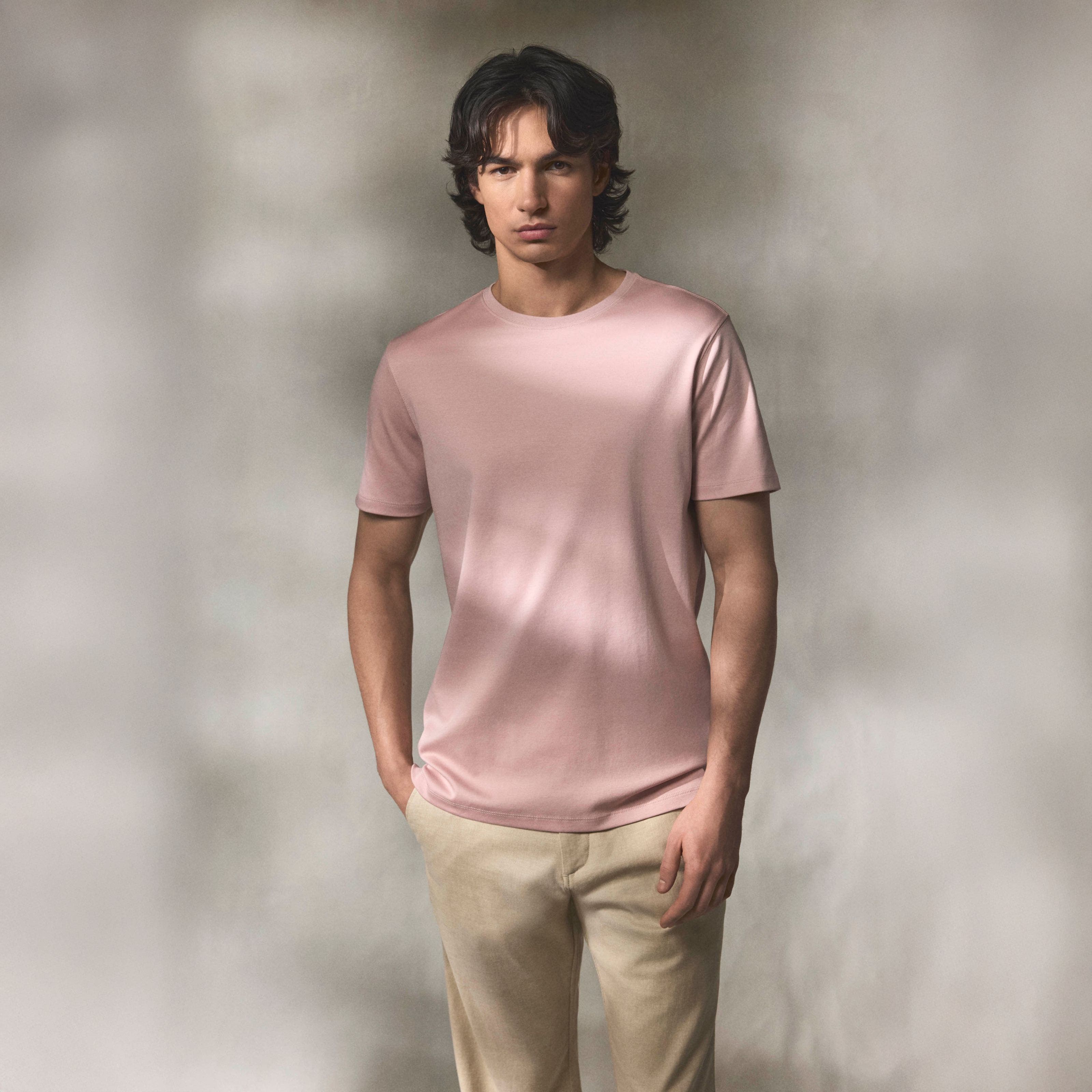 A man wearing a light-pink crewneck T-shirt.