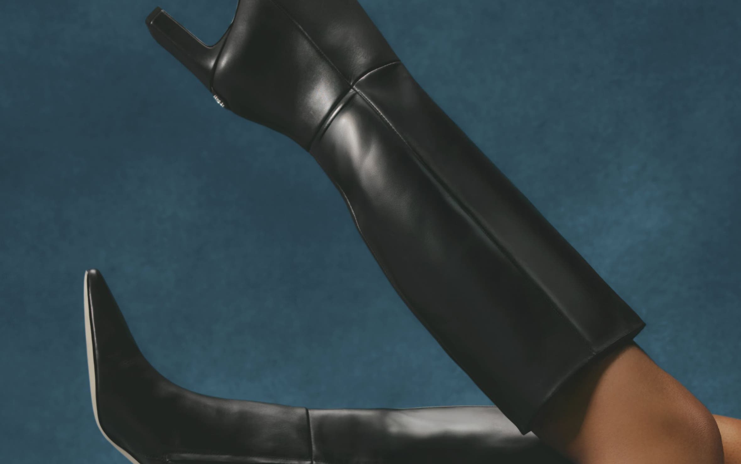 Woman's legs in the air wearing heeled boots.