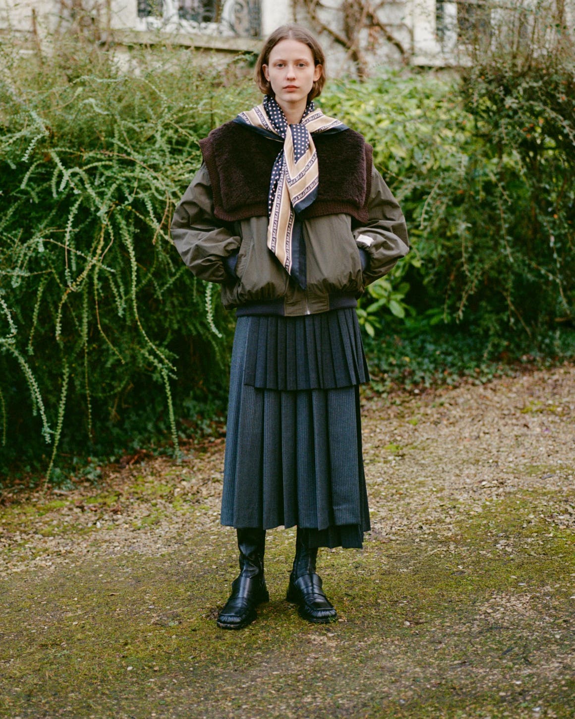 A woman wearing a coat and skirt.