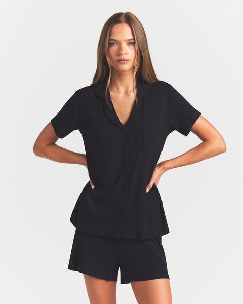 Woman wearing black short sleeve and short matching pajamas.
