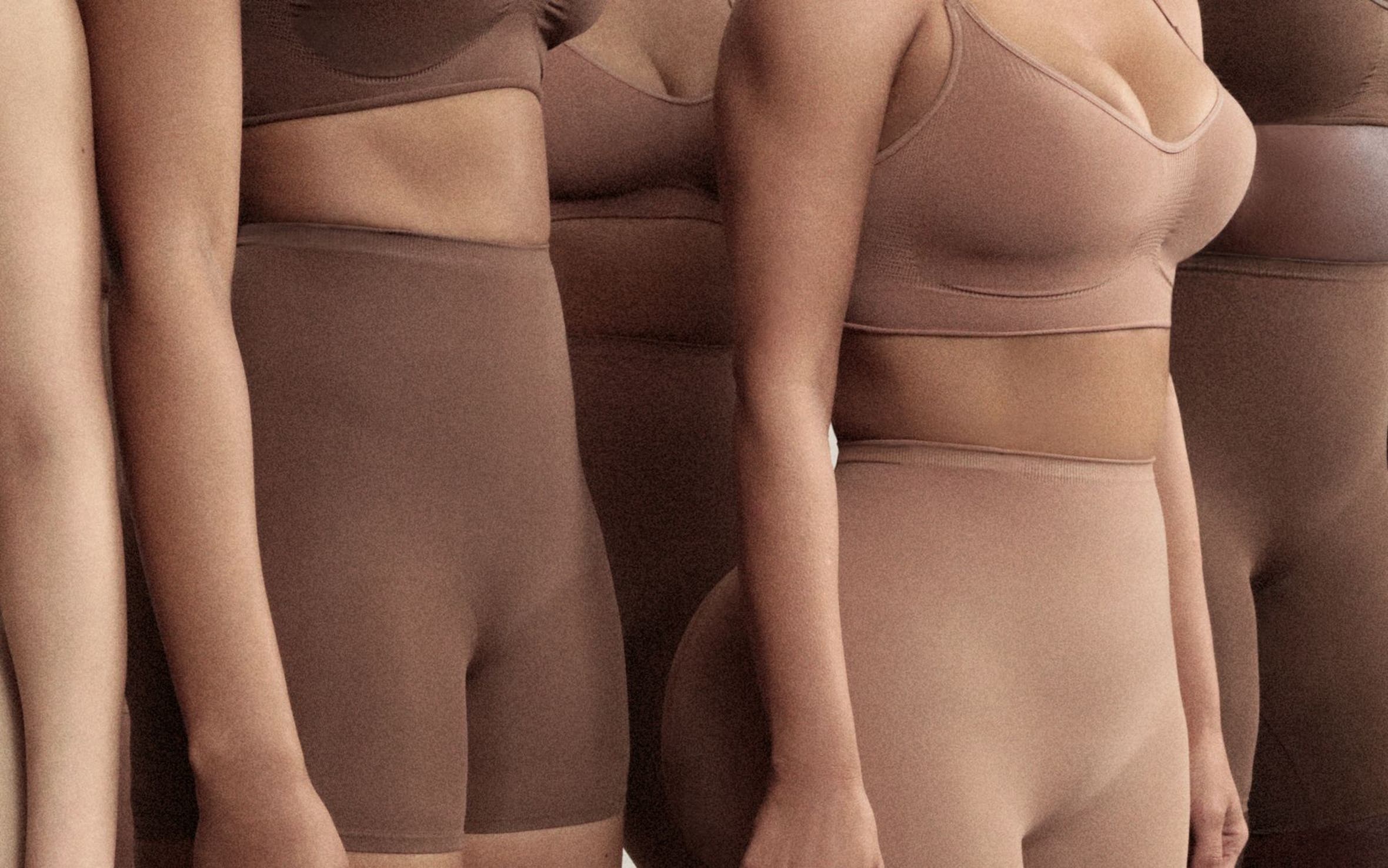 A group of women wearing shapewear and bras by SKIMS.