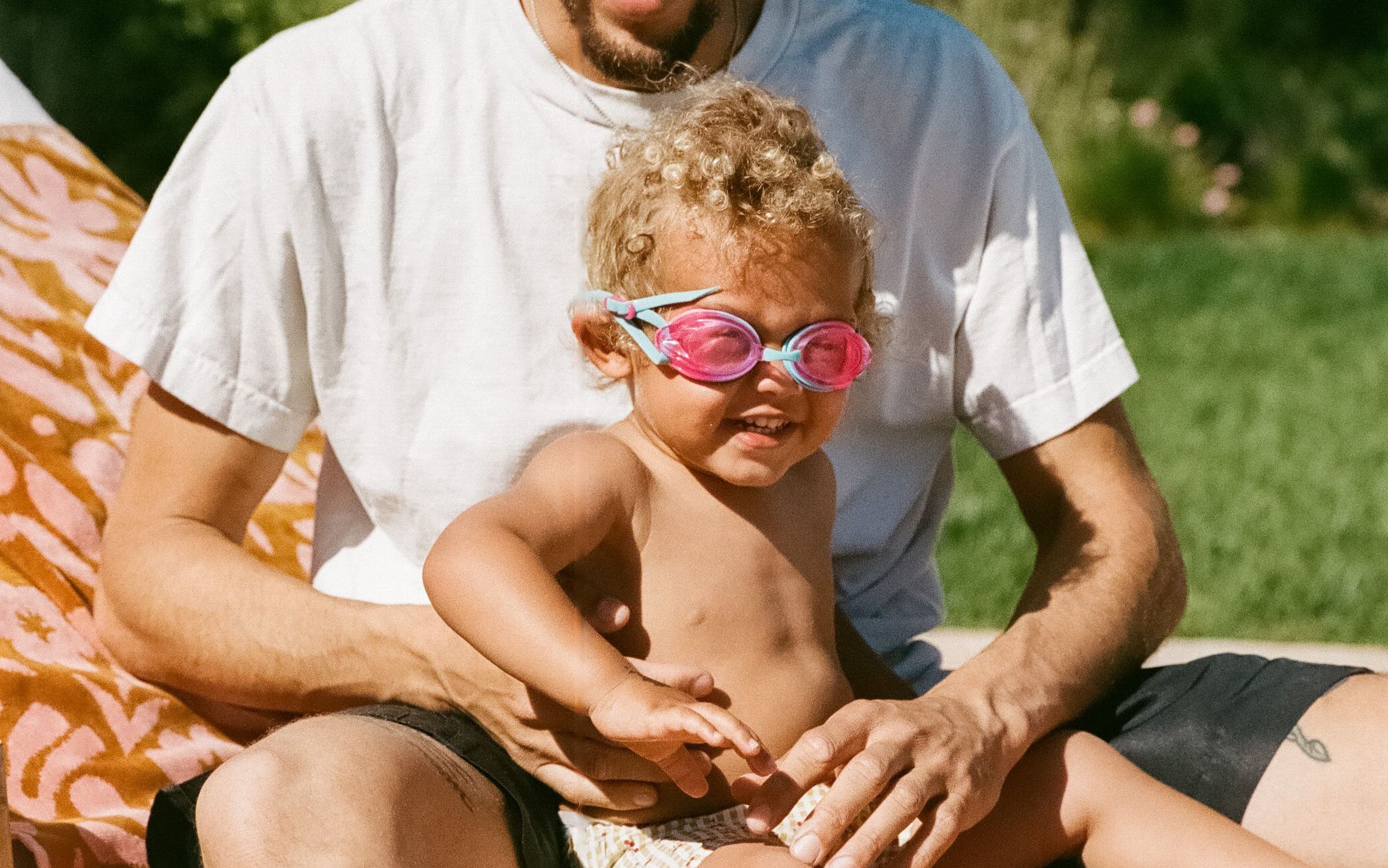 a man and a child sitting on a towel. 
